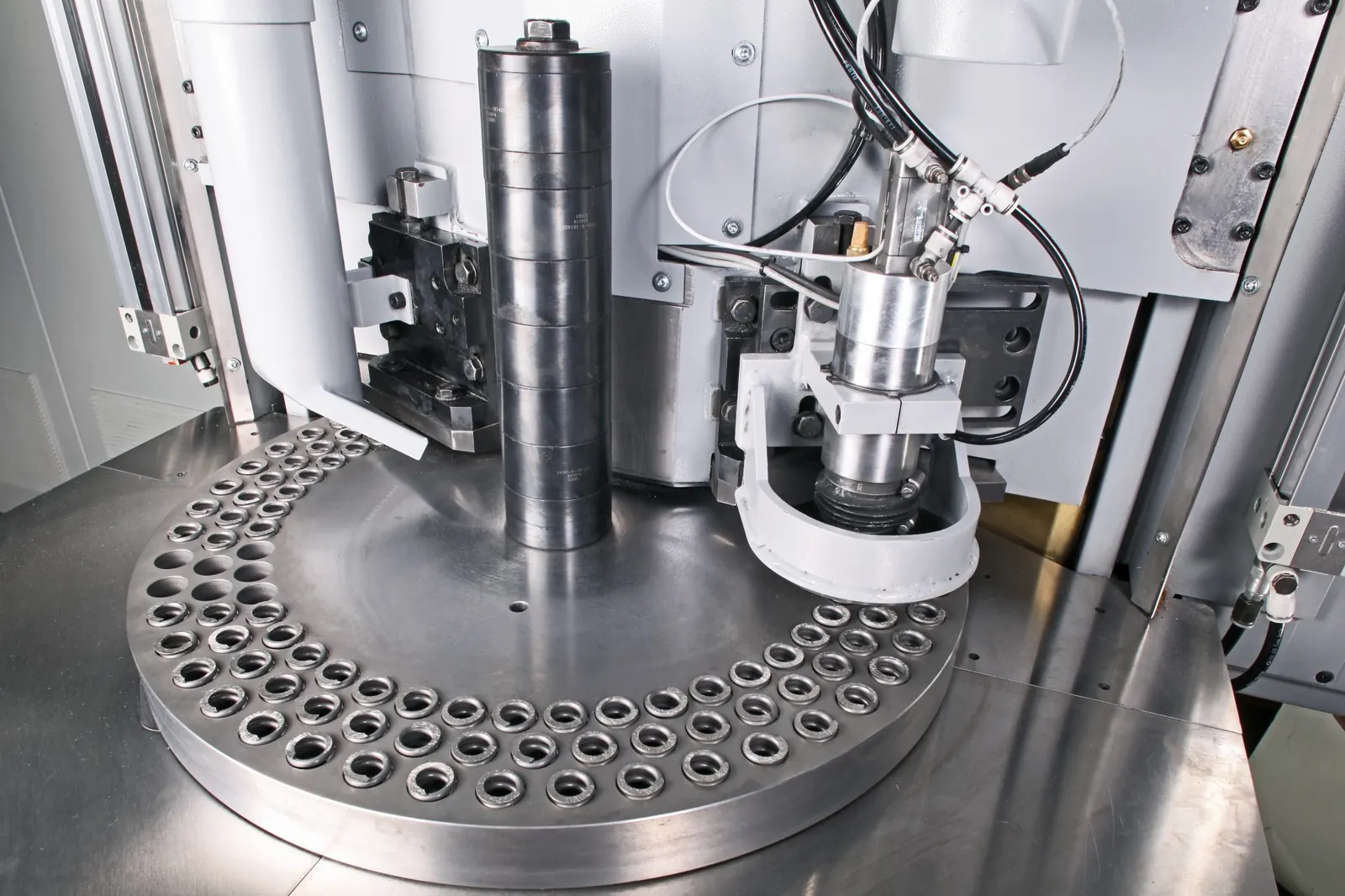 Spring end grinding machine with a loaded grinding plate